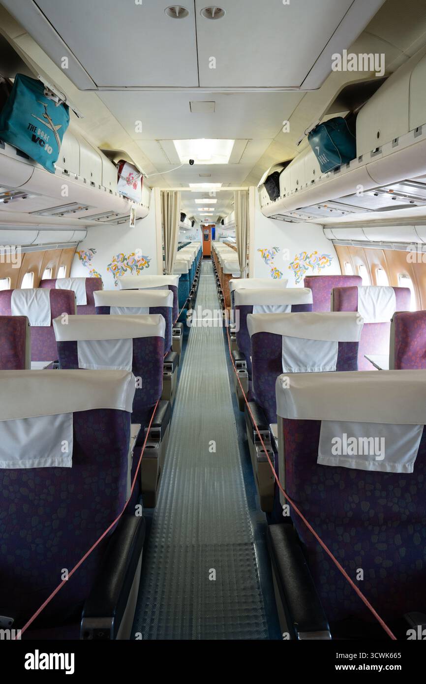 Intérieur de cabine d'avion avec sièges violets et compartiments à bagages au-dessus de la tête Banque D'Images