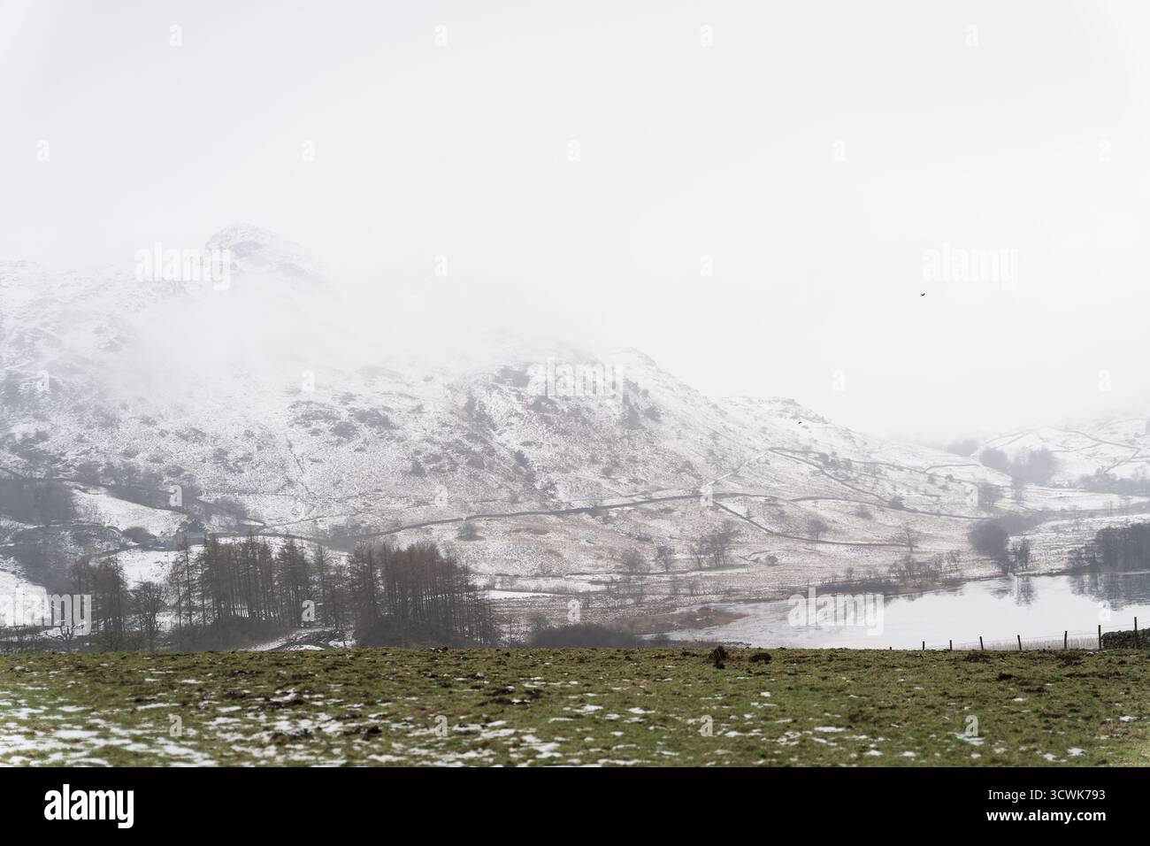 Des puits enneigés et une vallée brumeuse dans le paysage hivernal du Lake District Banque D'Images