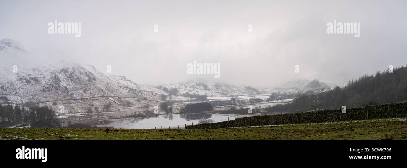Des puits enneigés et un panorama de la vallée dans le Lake District par un matin d'hiver brumeux Banque D'Images