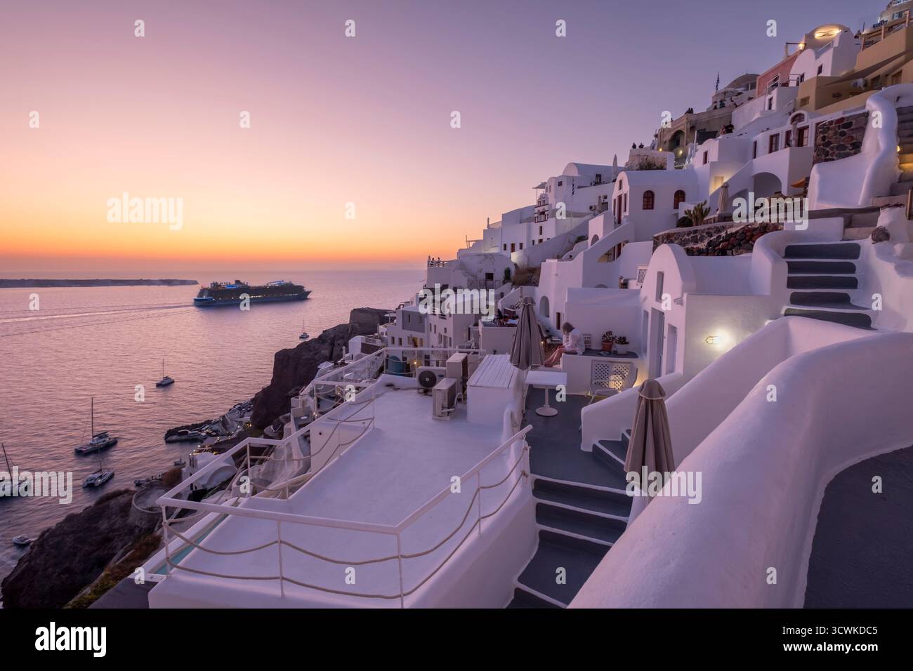 Un grand bateau de croisière quittant Santorin lors d'un beau coucher de soleil Banque D'Images