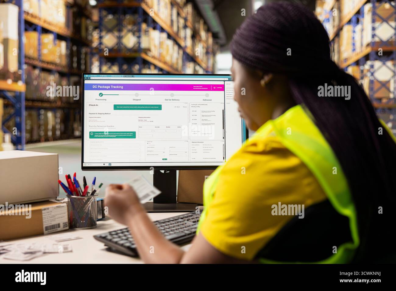 Commis d'entrepôt vérifiant les numéros de facture de transport aérien pour le logiciel de suivi, assurant une livraison express transparente et le suivi des commandes sur ordinateur. Femme manipulant les étiquettes d'expédition. Banque D'Images
