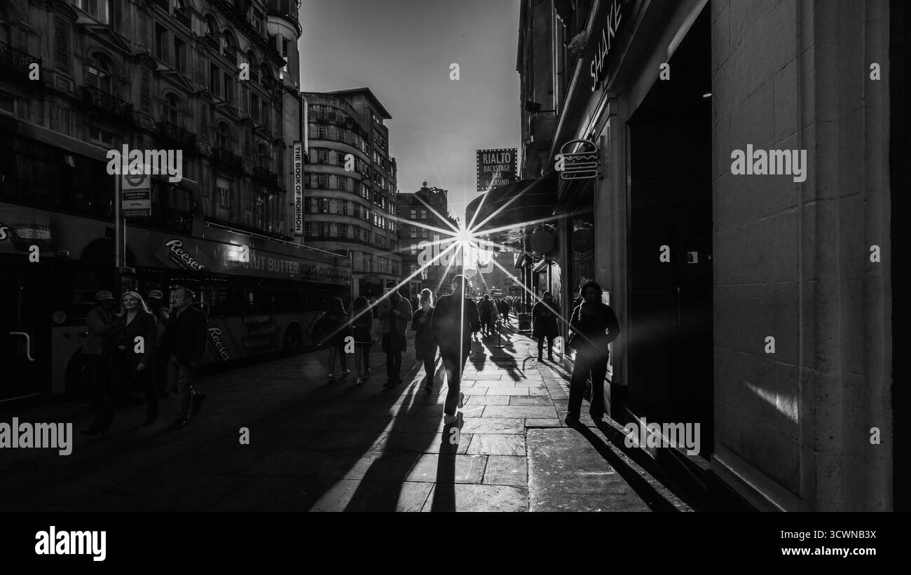 Une image en noir et blanc de rayons de soleil violents au-dessus de l'extrémité ouest dans le centre de Londres. Banque D'Images