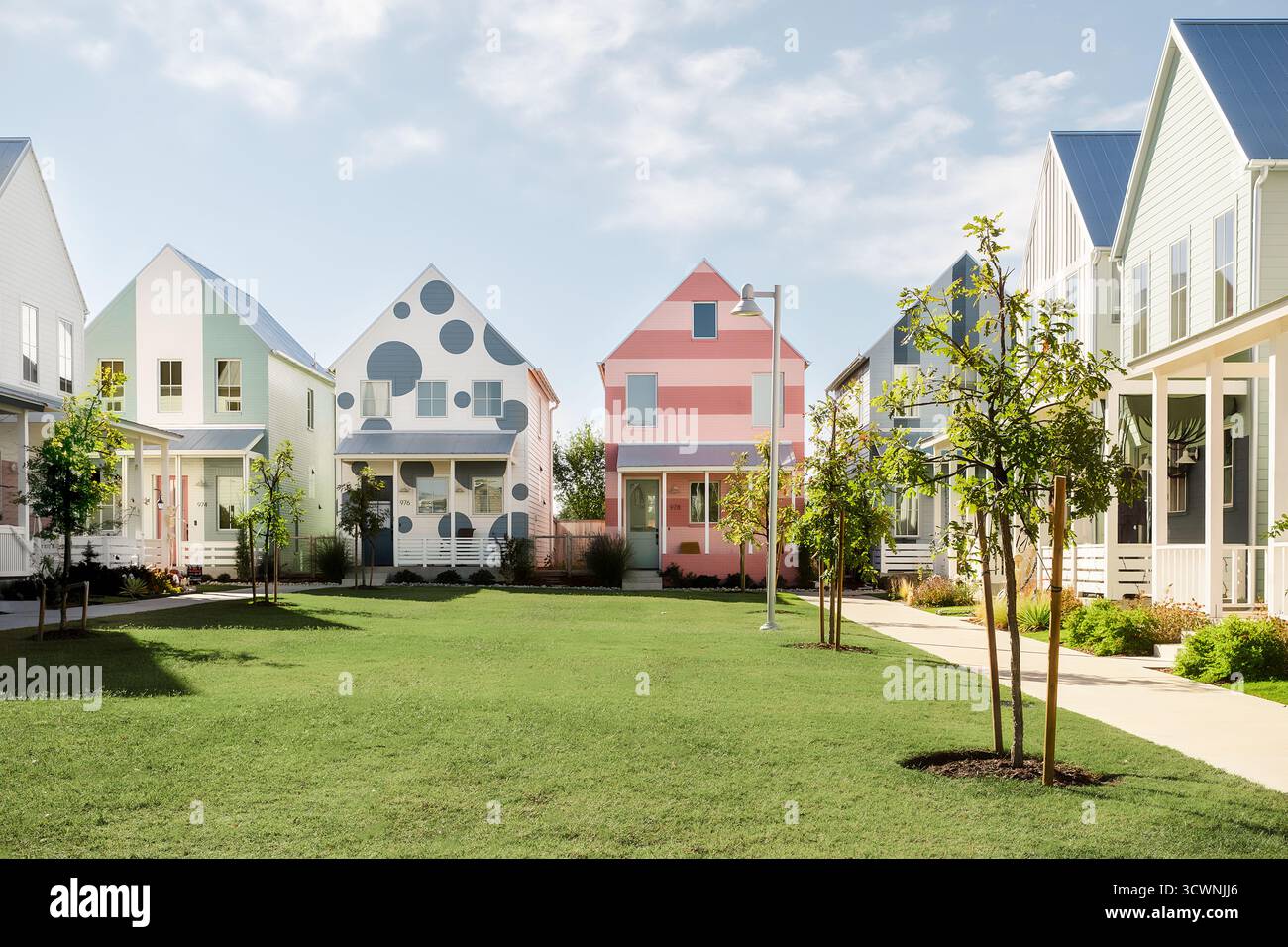 Maisons modernes colorées pastel dans une cour herbeuse Banque D'Images