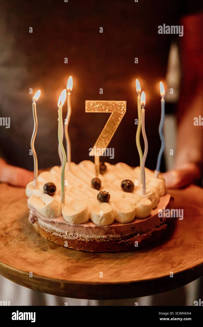 Gâteau d'anniversaire avec des bougies et topper numéro sept doré Banque D'Images