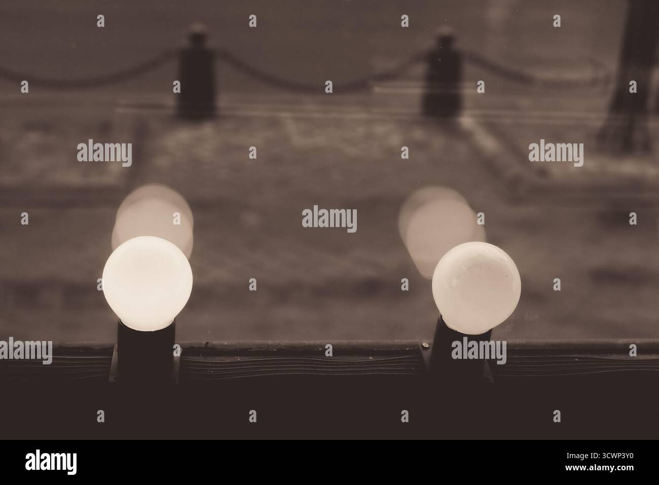 Gros plan de deux ampoules rondes qui brillent doucement sur un fond urbain flou à Minsk, Biélorussie. Banque D'Images