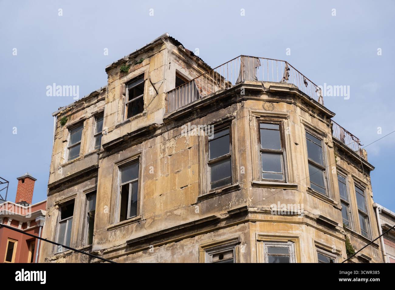 Bâtiment historique délabré avec des fenêtres brisées et une façade en ruine. Structure de maison abandonnée, ancienne et à plusieurs étages avec balcon négligé Banque D'Images