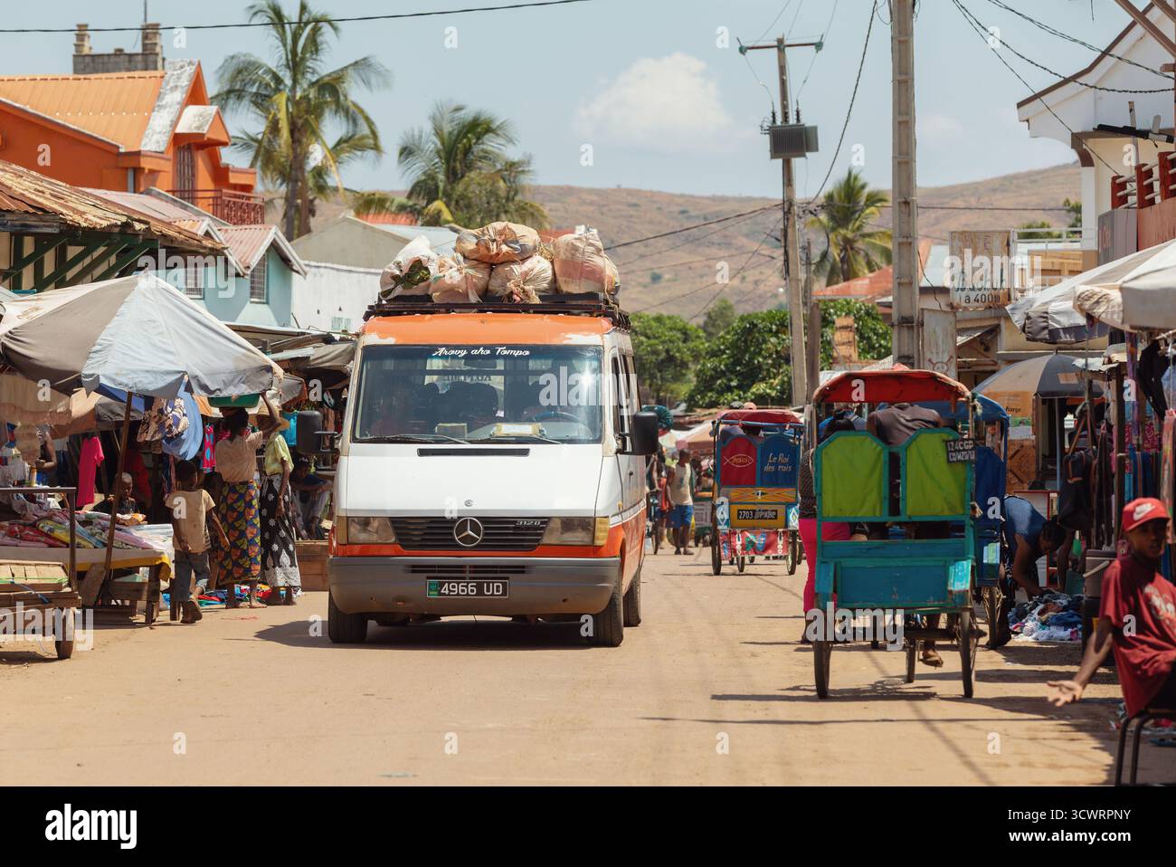 Miandrivazo, Madagascar - 11 octobre 2025 : un minibus surchargé (taxi-brousse) transportant des marchandises et des passagers à travers la ville animée de Miandri Banque D'Images
