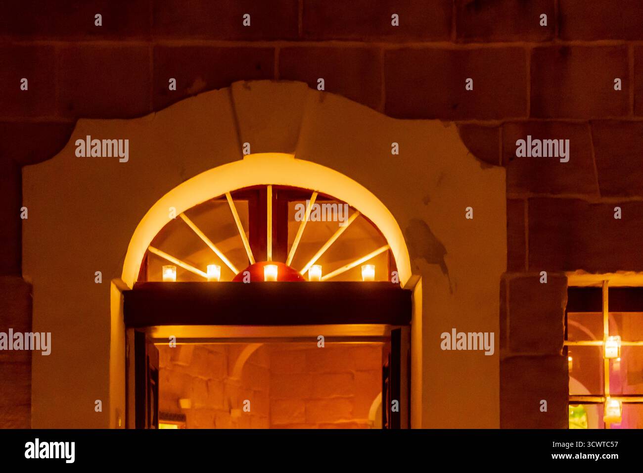 Porte Arch chaude aux chandelles avec Amber Glow à l'intérieur D'Un bâtiment en brique Banque D'Images