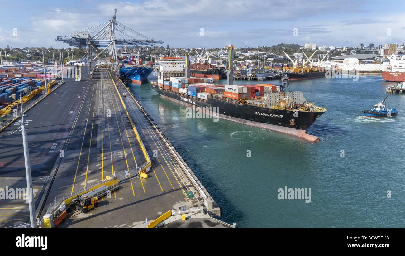Auckland, Nouvelle-Zélande - 19 septembre 2025 : vue aérienne d'un porte-conteneurs, chargé de cargaisons vibrantes, glisse dans le port près de Tooley Street, reflétant les teintes Azur du ciel. Banque D'Images