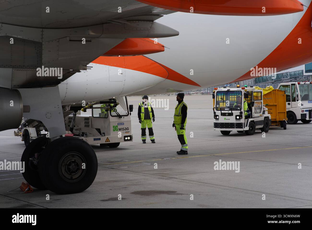 WISAG personnel au sol et véhicules de service travaillant sous un avion EasyJet pendant les opérations au sol à l'aéroport de Munich.Munich, Allemagne Banque D'Images