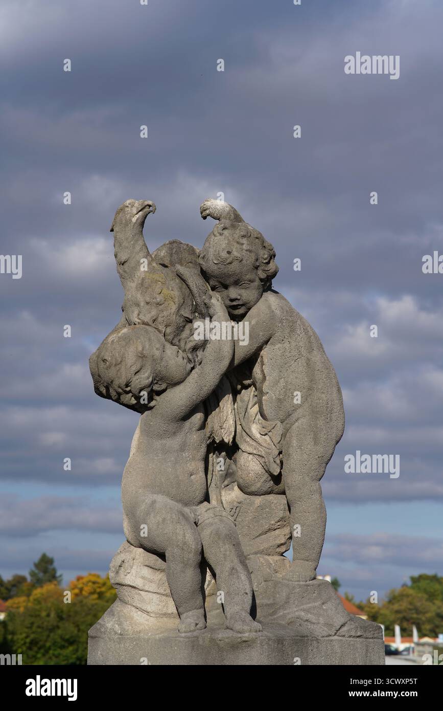 Sculpture baroque en pierre de chérubins ludiques dans les jardins du palais de Nymphenburg, Munich, illuminée par la lumière de l'après-midi. Palais de Nymphenburg, Munich Banque D'Images