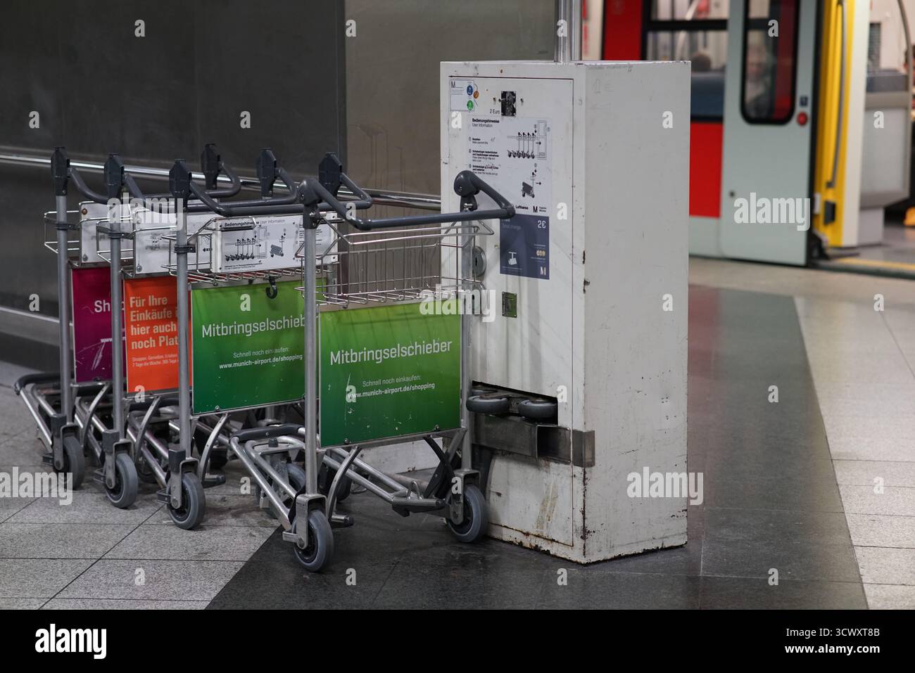Chariots à bagages et distributeur de retour près de la gare de l'aéroport de Munich, montrant les facilités de connexion de transport de l'aéroport.Munich, Allemagne Banque D'Images
