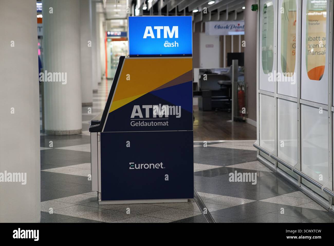 Distributeur automatique de billets Euronet dans le couloir du terminal de l'aéroport de Munich, éclairé la nuit pour l'usage des passagers.Munich, Allemagne Banque D'Images
