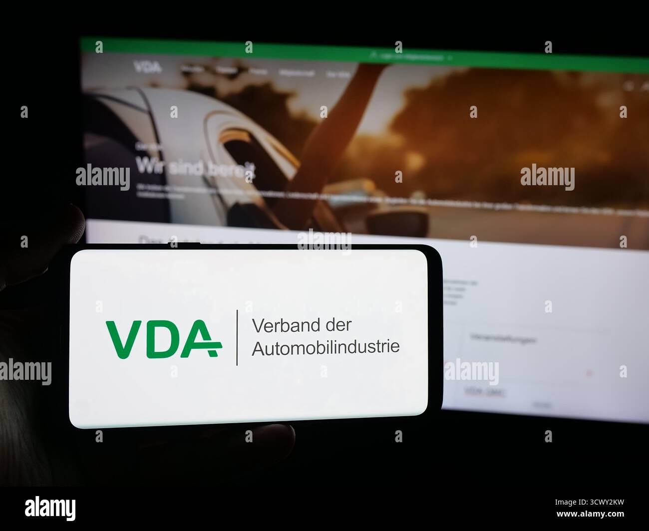 Stuttgart, Allemagne - 10-06-2025 : personne tenant un smartphone avec le logo de German Verband der Automobilindustrie (VDA) sur l'écran devant le site Web. Banque D'Images