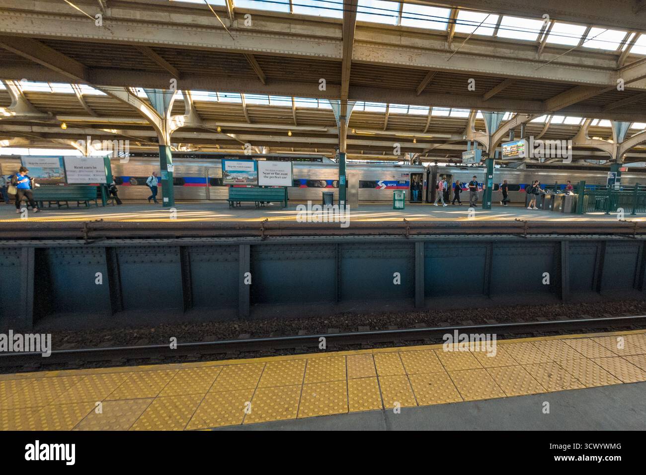 Une station Spring Garden avec un train sur les rails. Il y a plusieurs personnes debout autour de la plate-forme Banque D'Images Une station Spring Garden avec un train sur les rails. Il y a plusieurs personnes debout autour de la plate-forme Banque D'Images