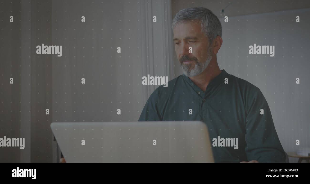 Typage homme adulte mature se concentrant sur l'écran au bureau à domicile, avec ordinateur portable argenté, espace de copie Banque D'Images