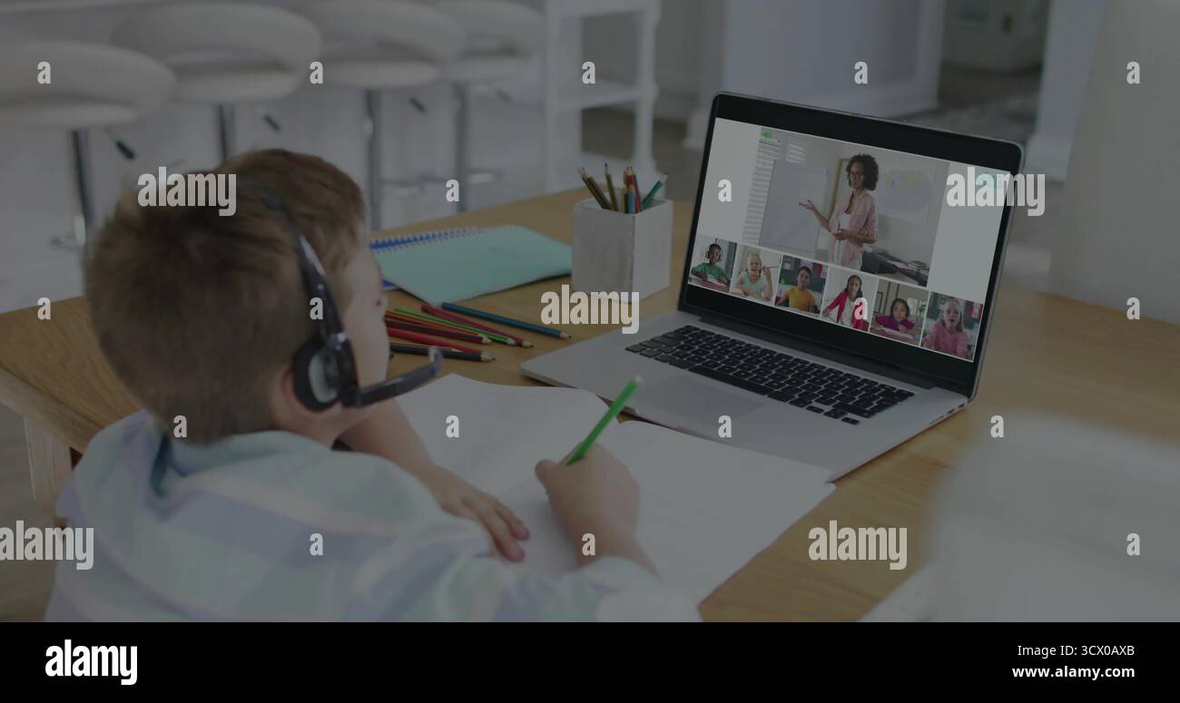 Rejoindre un écolier portant un casque dans la classe en ligne au bureau à la maison, avec ordinateur portable, crayons, espace de copie Banque D'Images