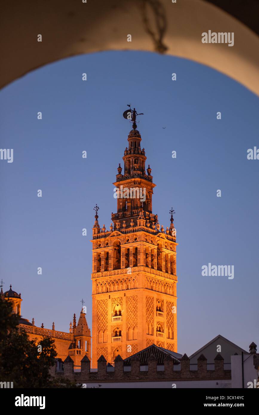 Une vue sur la Giralda, clocher de la cathédrale de Séville, la nuit à travers une arche voisine. Sud de l'Espagne. Banque D'Images