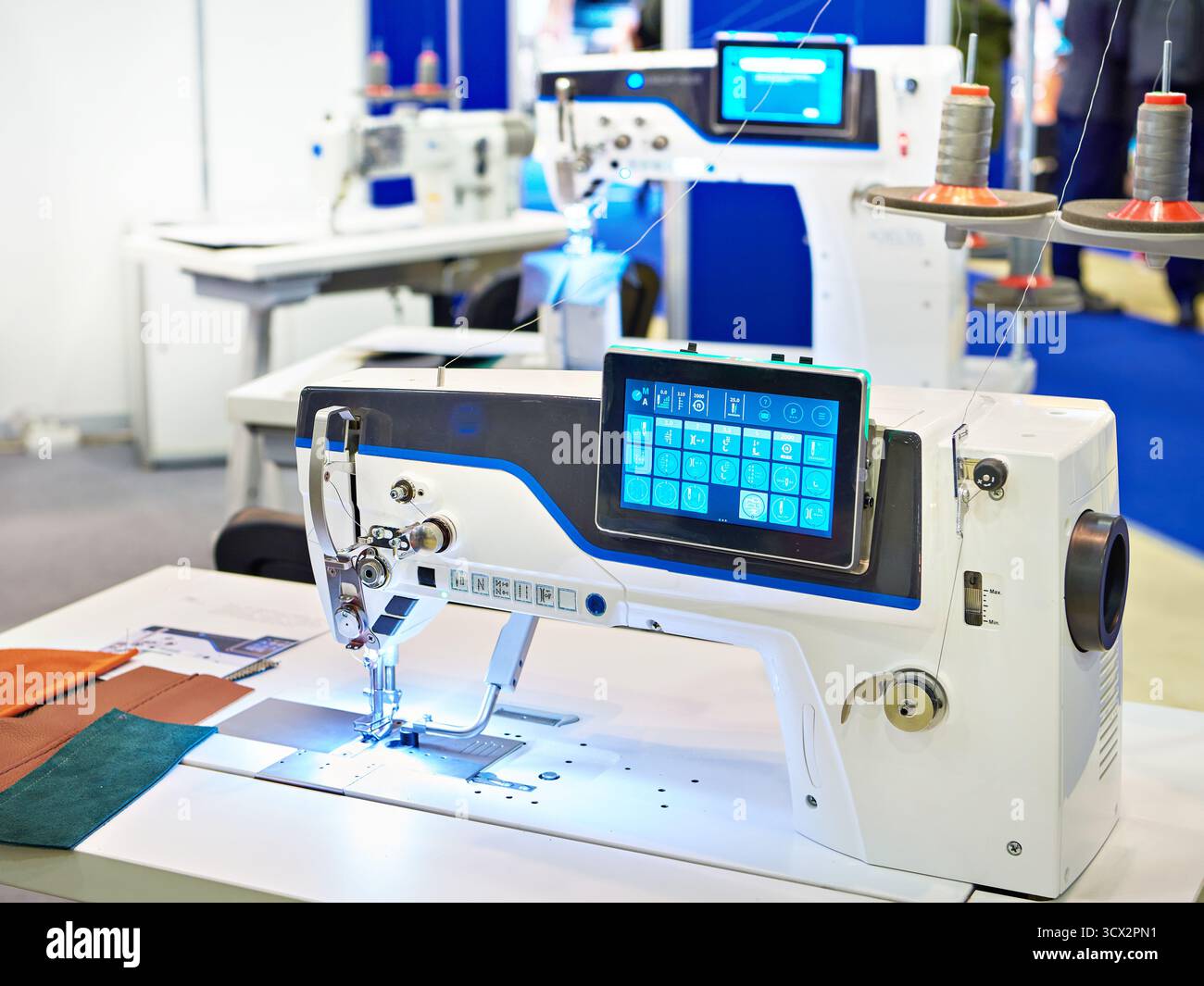 Machine à coudre industrielle avec plate-forme plate à double point de chaîne, unité d'entraînement programmable numérique pour une utilisation sur les tissus moyens Banque D'Images