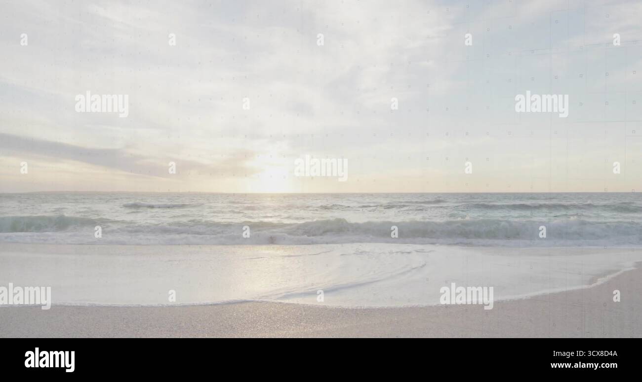 Vagues de l'océan roulant s'approchant du littoral sablonneux lisse au coucher du soleil, sous des nuages pastel éparpillés Banque D'Images