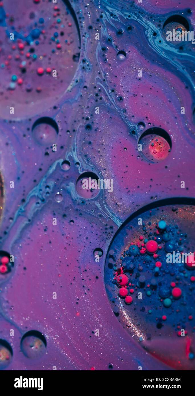 Éclaboussure d'encre. Fond de bulles. Défocalisé couleur bleu rose violet brillant eau ronde texture huile coulant sur art abstraction vibrante. Banque D'Images