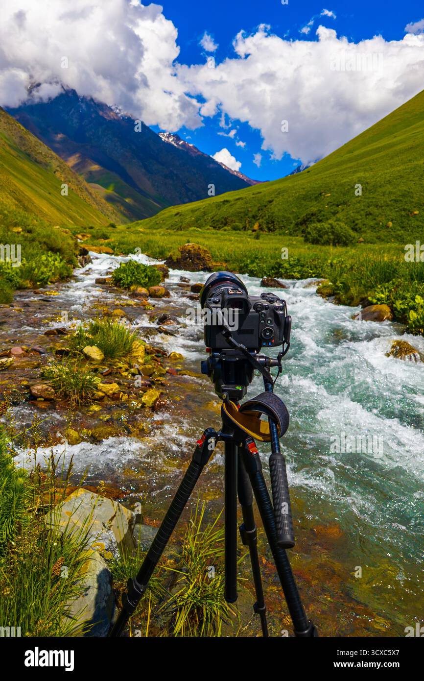Caméra sur trépied surplombant le paysage paisible de la rivière montagneuse Banque D'Images