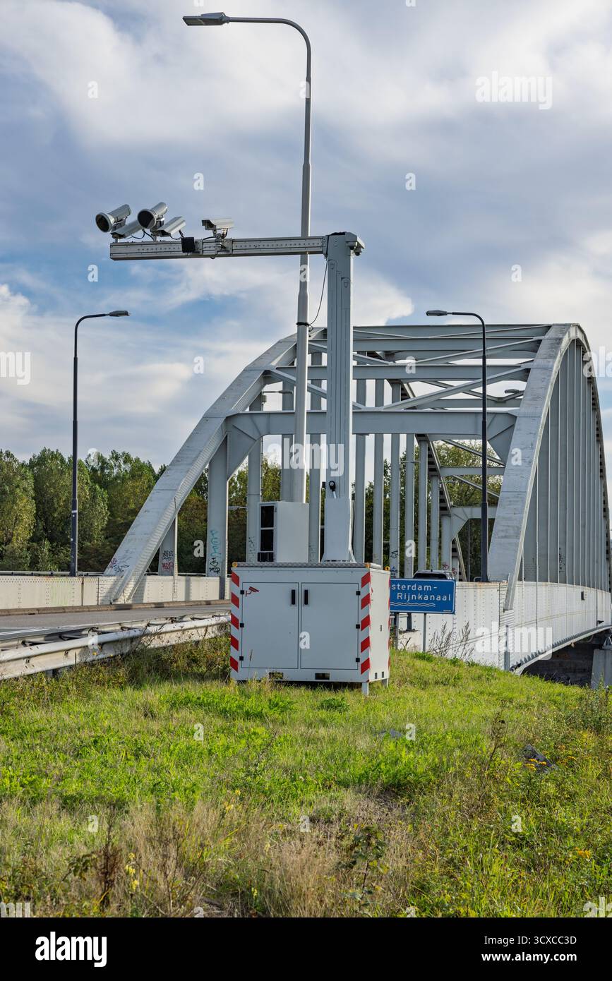 Plan vertical d'un système de caméra portable pour la vitesse du trafic et l'utilisation du téléphone, avec plusieurs caméras et flashs sur un mât haut près d'un pont néerlandais Banque D'Images