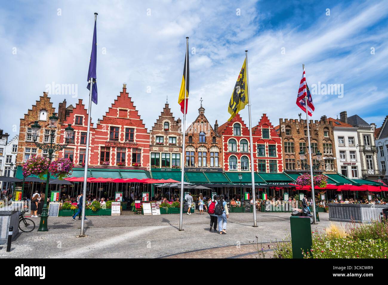 Ancienne guilde abrite maintenant des restaurants colorés sur la place du marché dans le centre historique de Bruges en Flandre occidentale, Belgique, Europe Banque D'Images