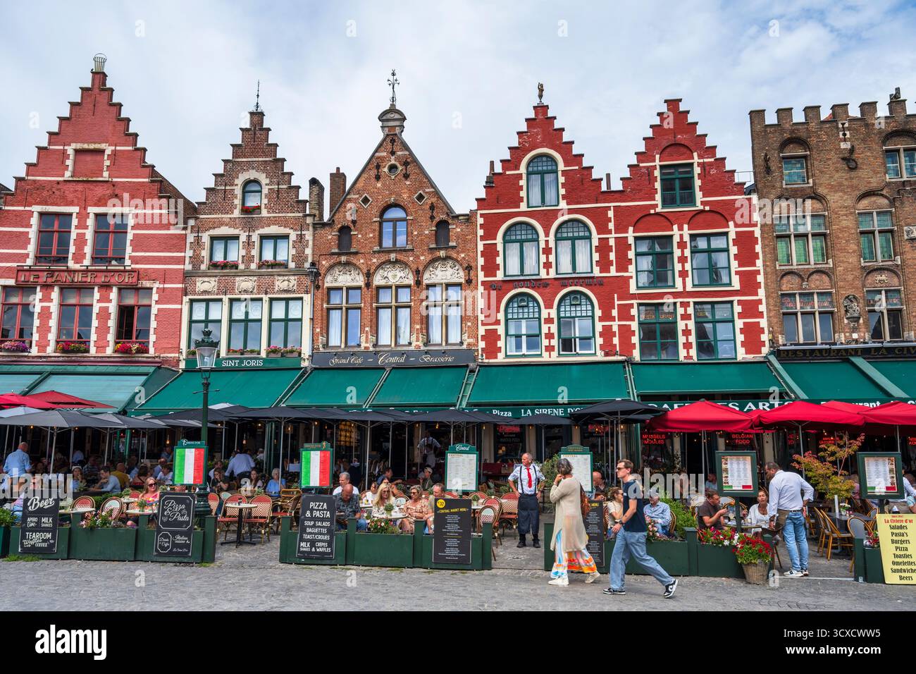 Ancienne guilde abrite maintenant des restaurants colorés sur la place du marché dans le centre historique de Bruges en Flandre occidentale, Belgique, Europe Banque D'Images