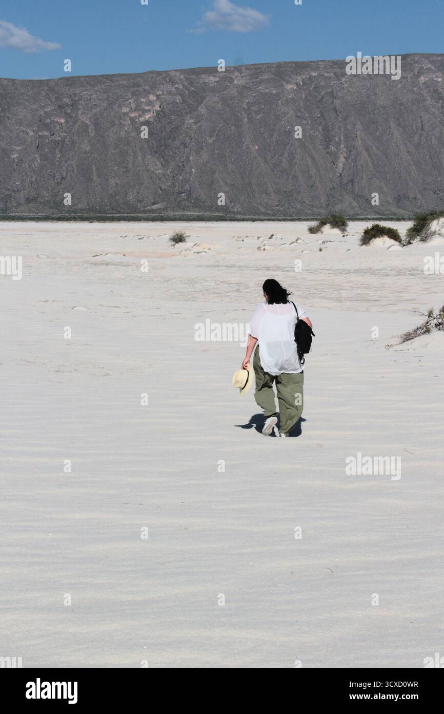 Brunette Latina femme adulte marche à travers les dunes de gypse au milieu du désert blanc profitant de la liberté et de la plénitude de sentir la nature Banque D'Images