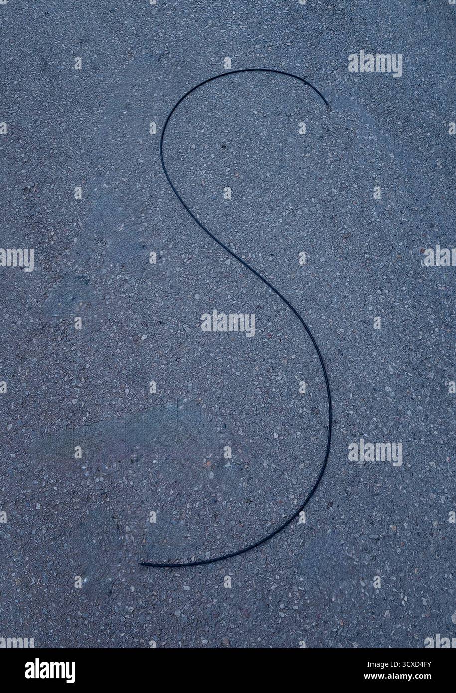 Accidentel S — câble tombé sur béton. Banque D'Images