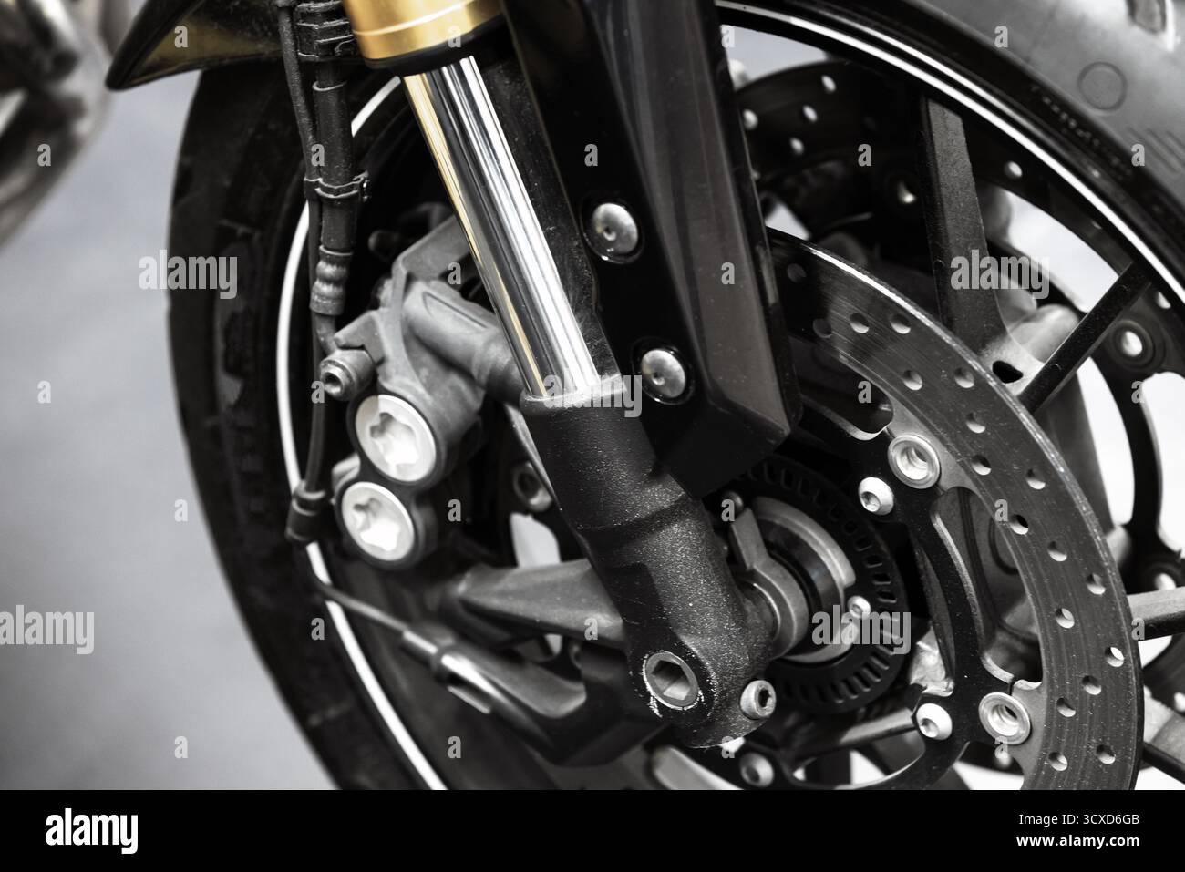 Photo détaillée en gros plan d'une roue avant de moto, frein à disque et fourches de suspension, vitesse de transport, puissance, et précision d'ingénierie idéale pour aut Banque D'Images