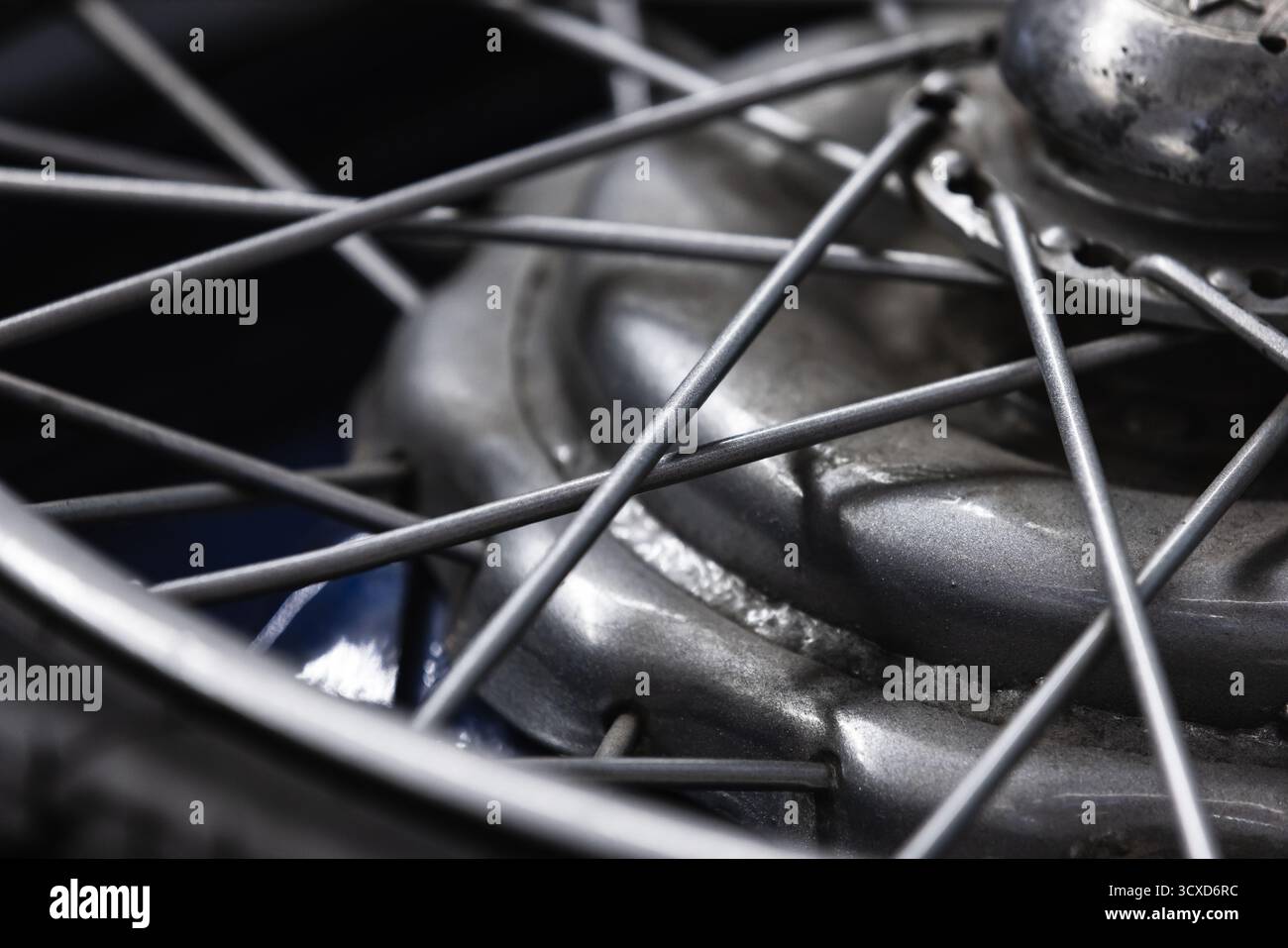 Vue rapprochée détaillée d'un moyeu de roue de moto, présentant les rayons, la jante et l'essieu. L'image monochrome souligne la texture du métal et le Preci mécanique Banque D'Images