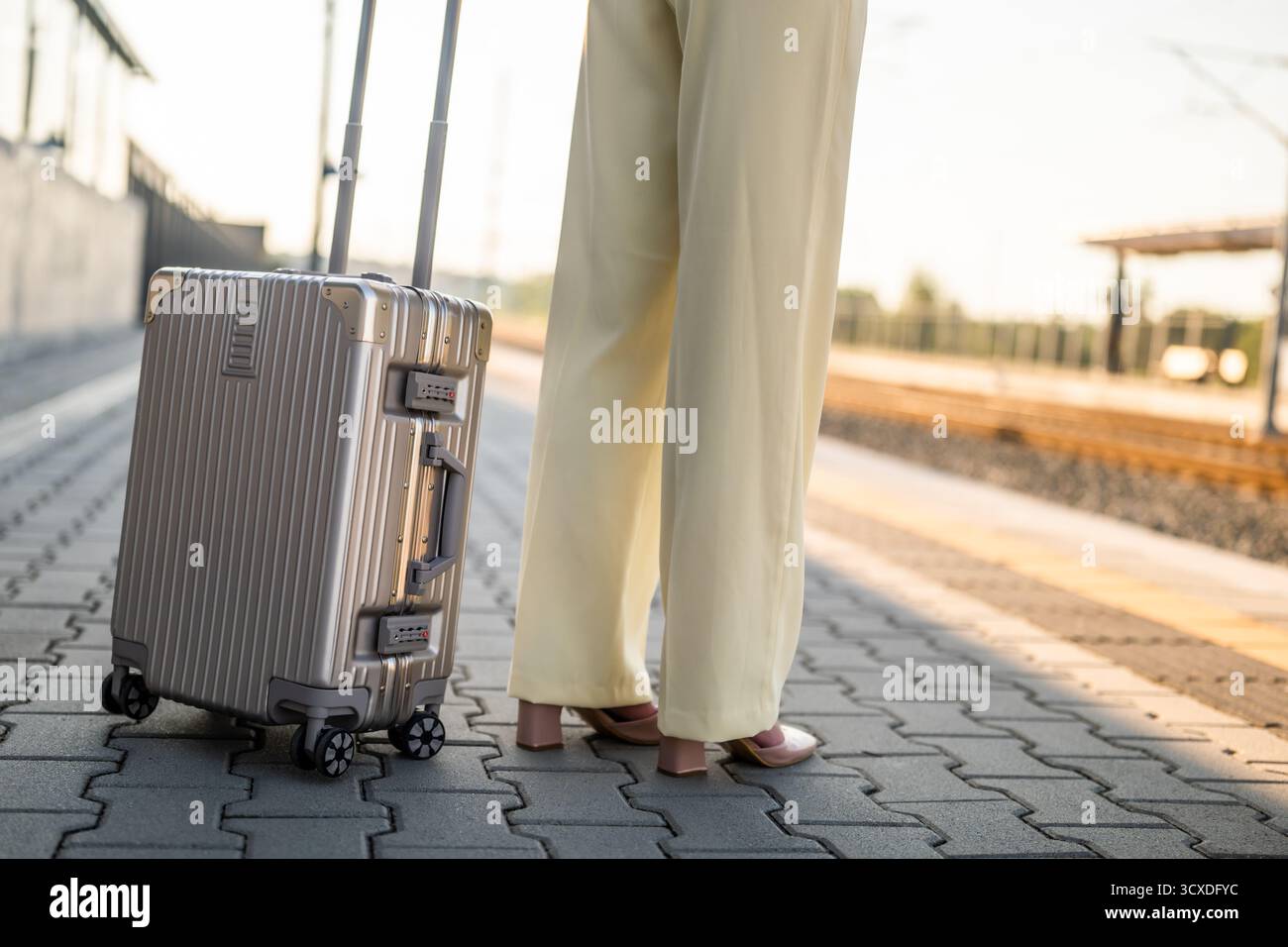 Gros plan image de femme d'affaires élégante tenant une valise et debout à la gare. Espace de copie pour votre texte ou publicité. Banque D'Images