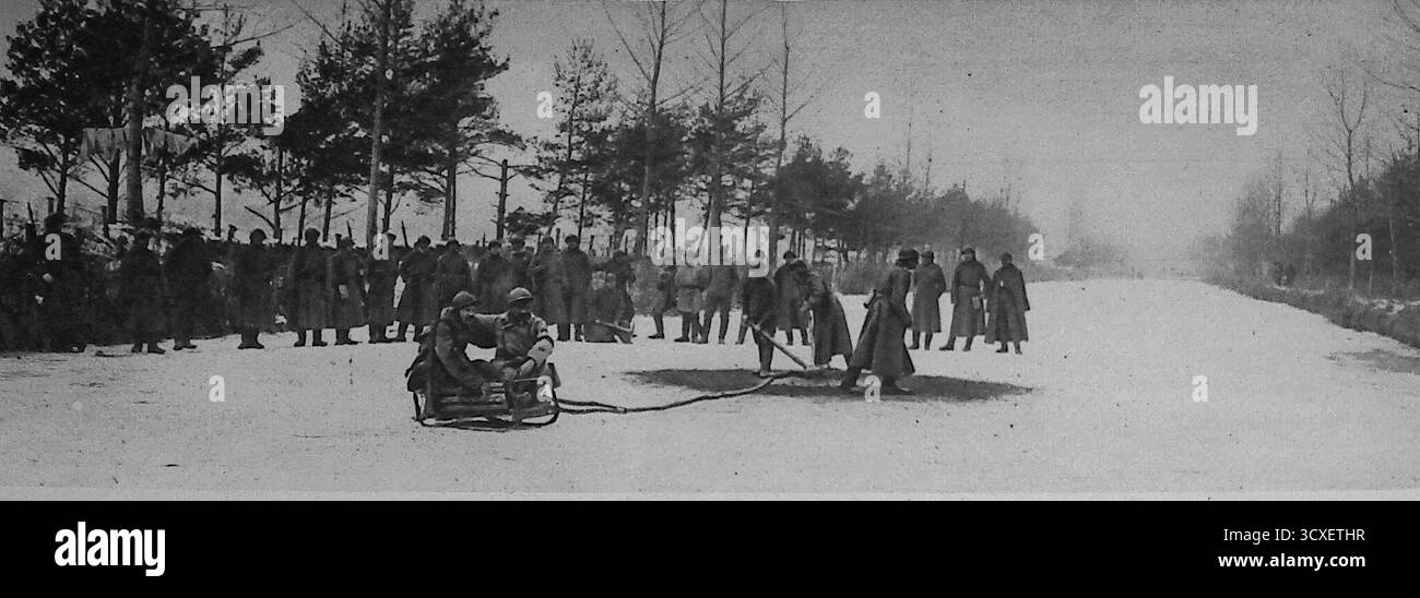 Du miroir, 4 mars 1917, montrant des soldats russes sur le front occidental en France en train de profiter d'un concours de luge. Les troupes sont rassemblées pour regarder les hommes descendre un canal glacé, visant des casquettes jetées en l'air. Ce passe-temps de guerre inhabituel, inspiré par la tradition française des « chasseurs de casquettes », reflète comment les soldats ont trouvé des moments de loisirs et de camaraderie malgré les dures réalités de la première Guerre mondiale Banque D'Images