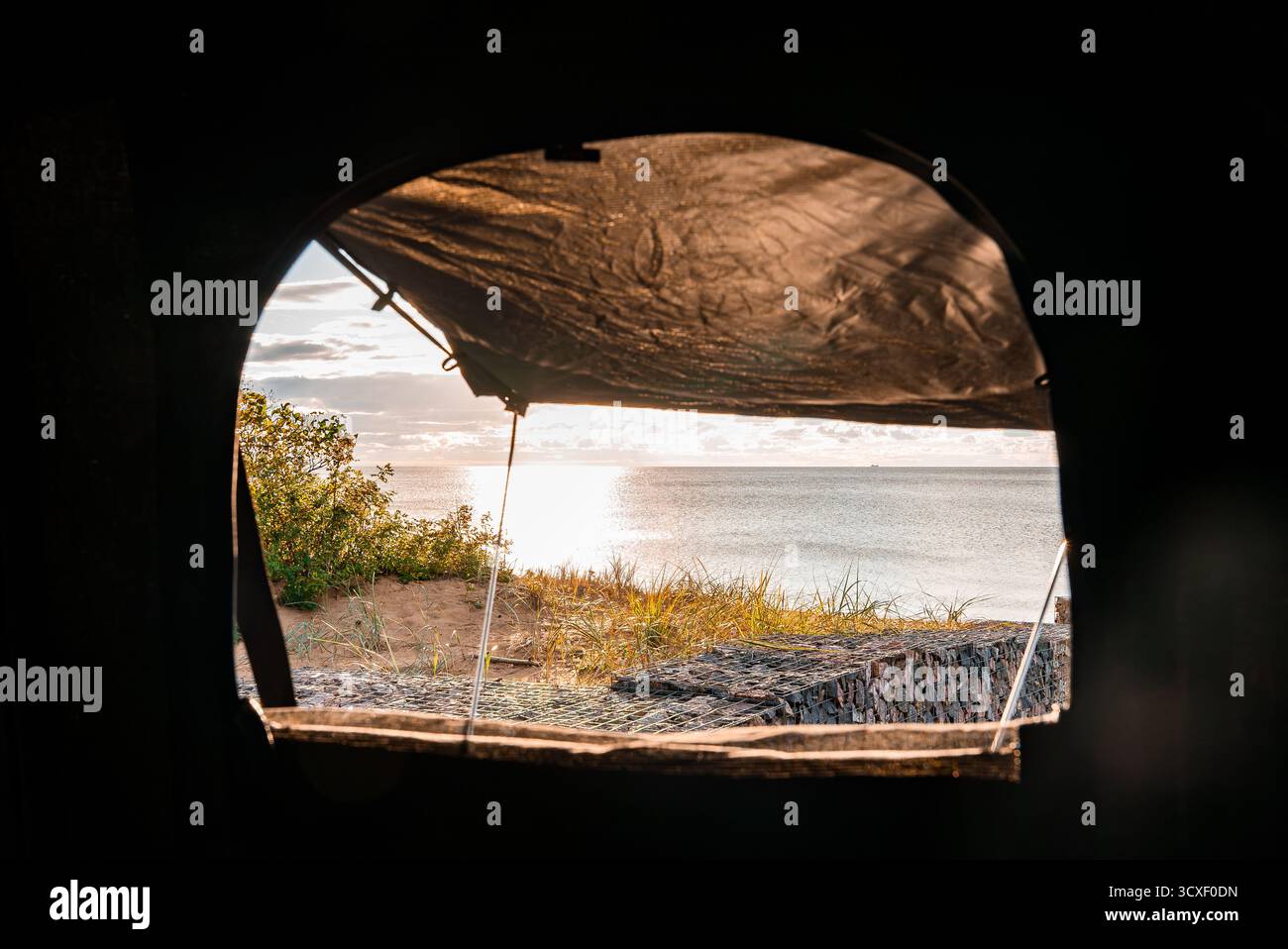 Vue sur la tente sur le toit vers l'océan calme et les dunes à l'heure dorée Banque D'Images