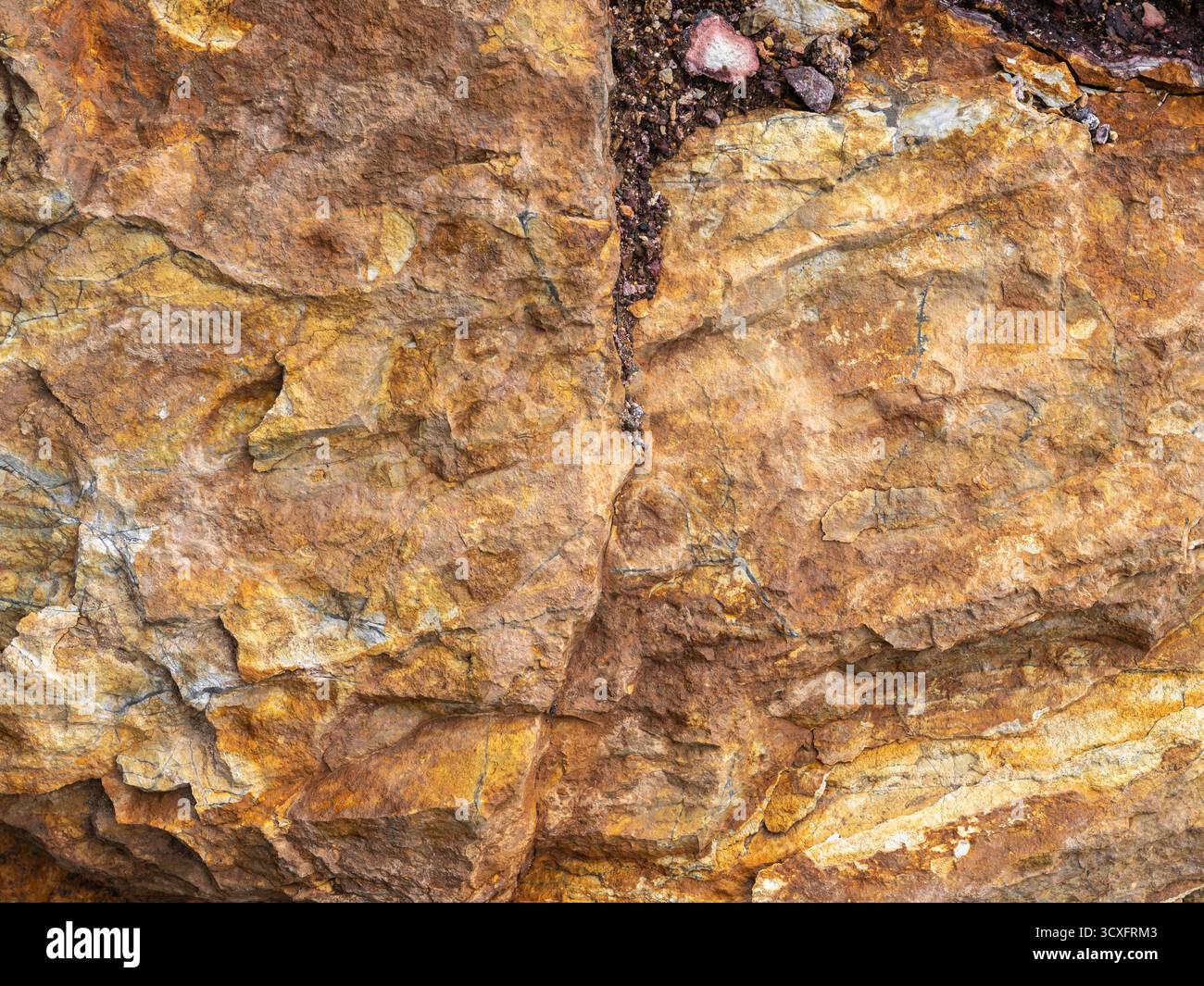 Gros plan de roches sédimentaires en couches avec des fissures, des textures et des tons minéraux terreux. Banque D'Images