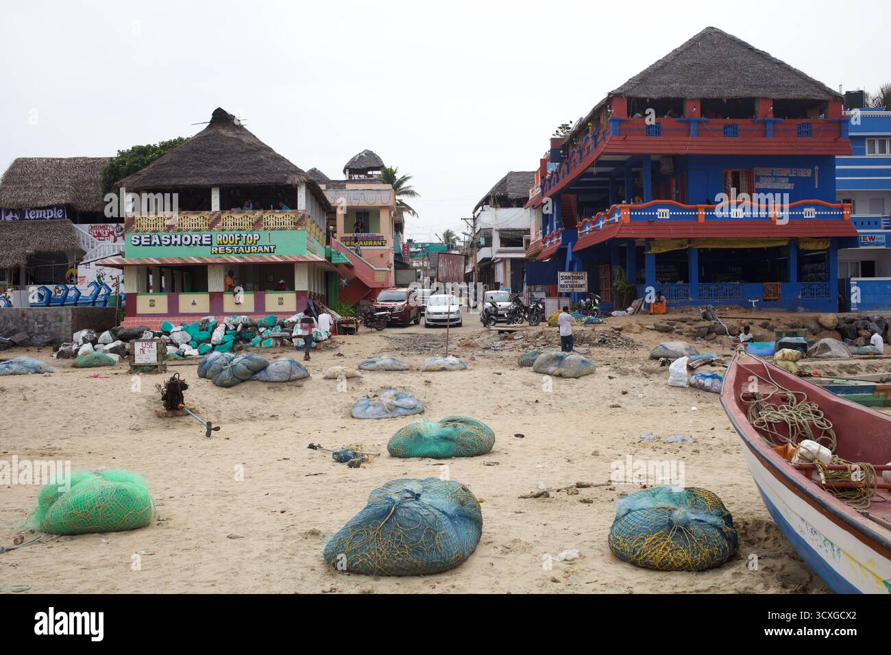 Filets de pêche empilés sur le sable devant le restaurant Seashore Rooftop à Mahabalipuram Beach, Tamil Nadu, où le tourisme rencontre les moyens de subsistance locaux. Banque D'Images