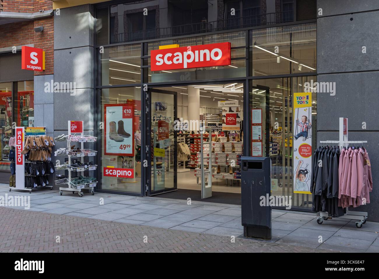 Vitrine de Scapino, un détaillant néerlandais de chaussures et de vêtements, affichant un logo rouge, de la marchandise sur des étagères et des affiches de vente dans les vitrines. Banque D'Images