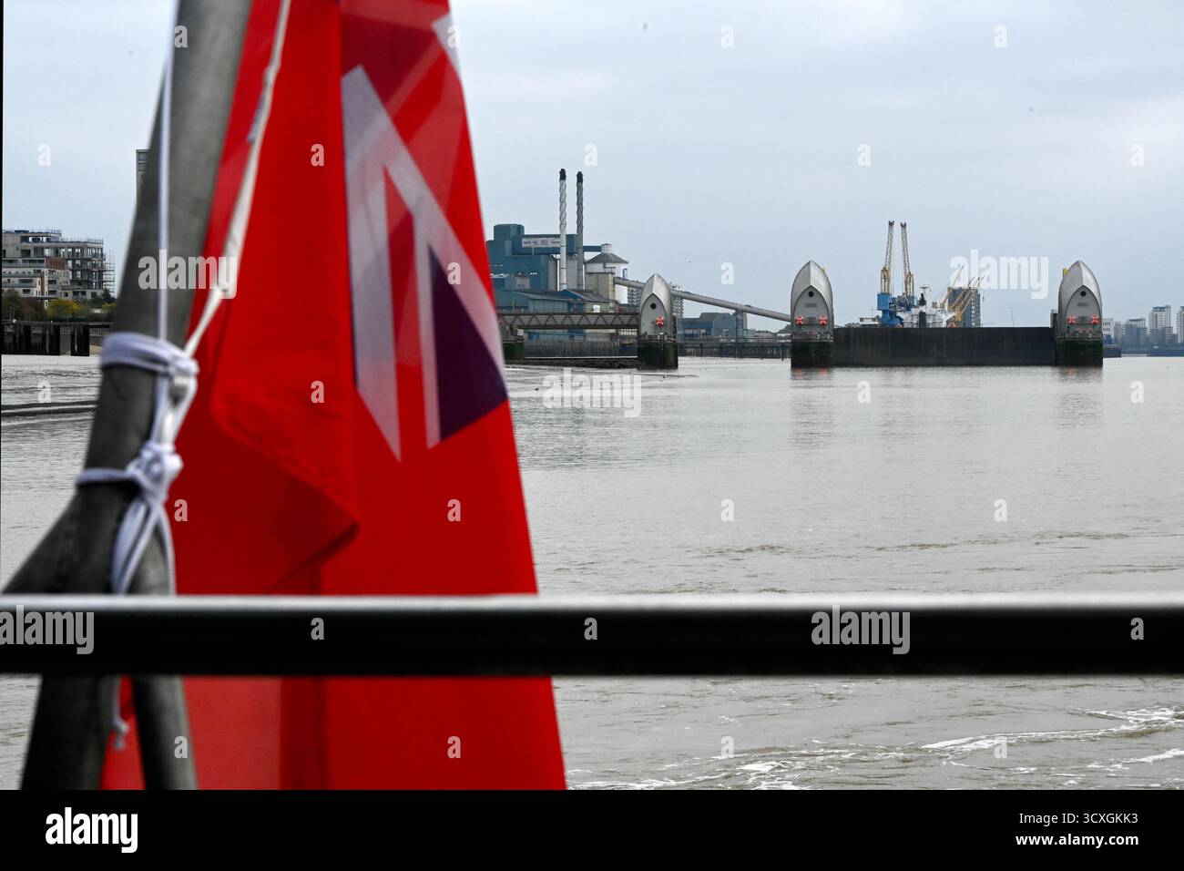 LONDRES, Royaume-Uni - 11 OCTOBRE 2025 : Red Ensign avec Thames Barrier en arrière-plan Banque D'Images