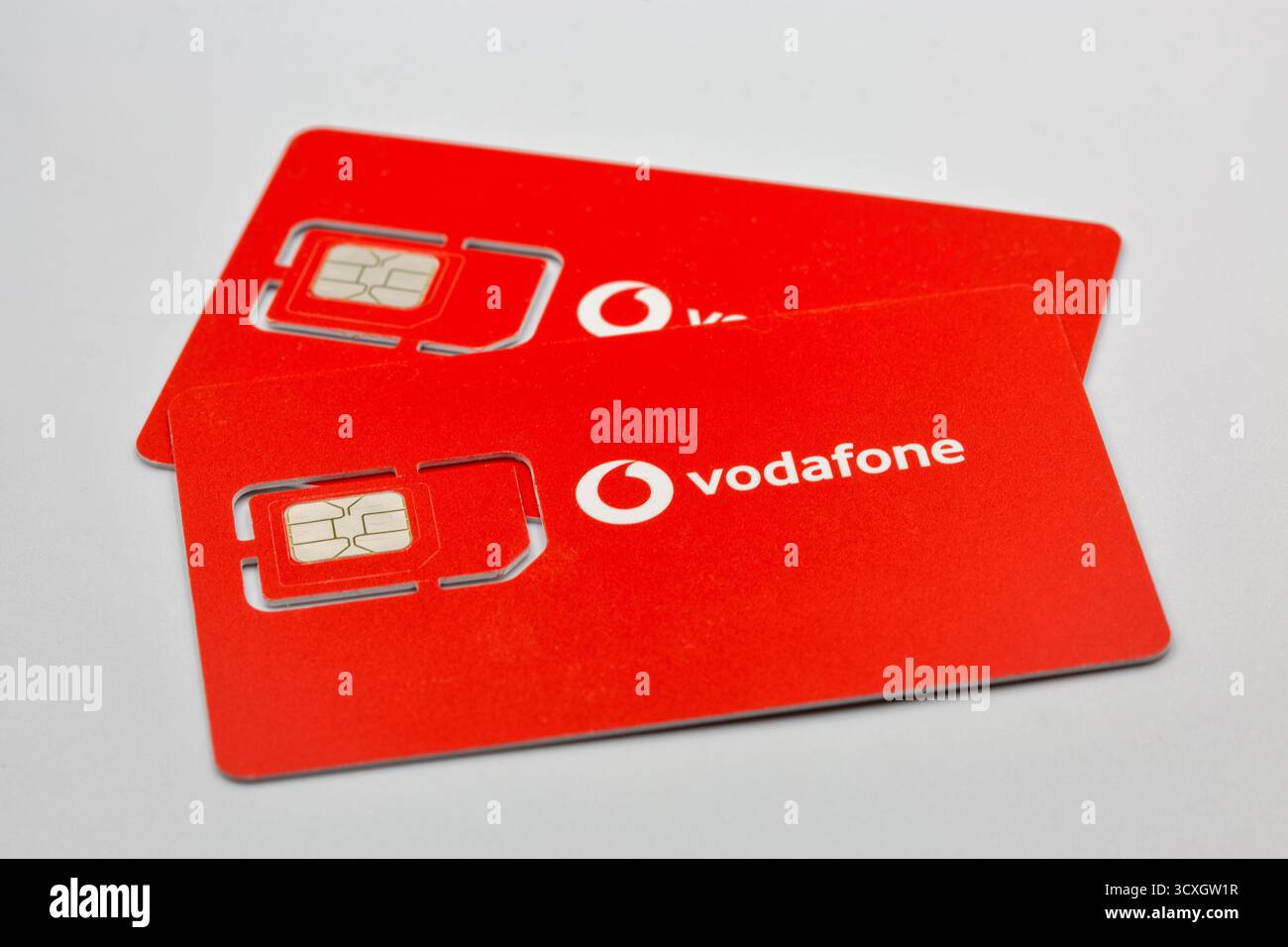 Kiev, Ukraine - 07 décembre 2024 : deux cartes SIM Vodafone rouges avec puce et logo en gros plan. Cartes prépayées d'opérateur de réseau mobile montrant standard et M. Banque D'Images