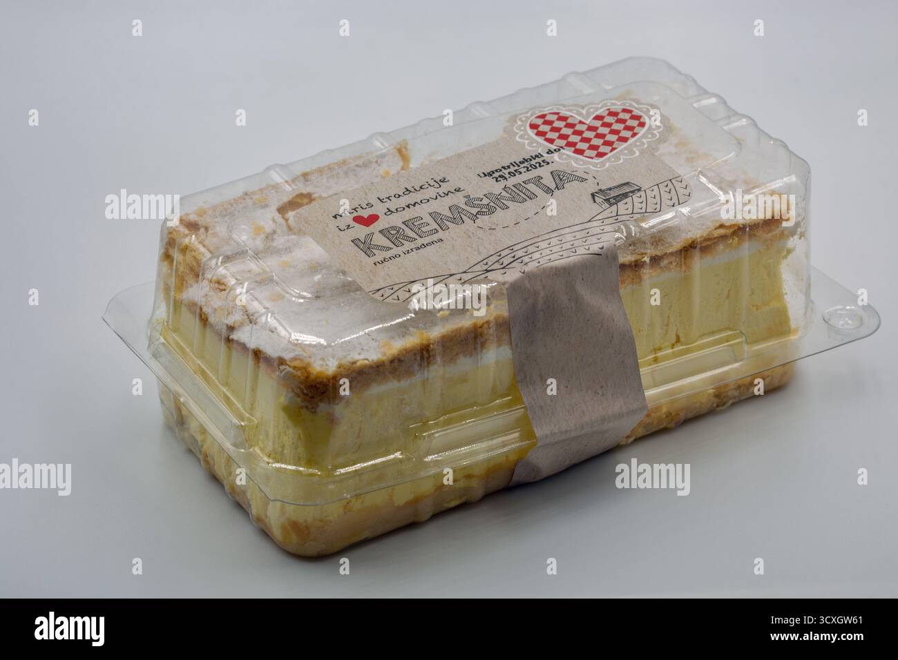 Porec, Croatie - 21 mai 2025 : gâteau croate à la crème anglaise kremsnita dans un emballage en plastique transparent gros plan sur blanc. Dessert en couches avec pâte feuilletée Banque D'Images