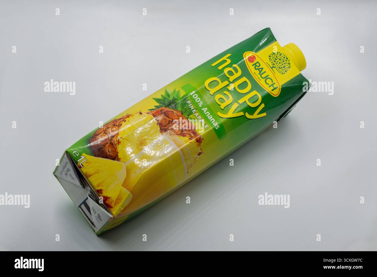 Tar, Croatie - 29 mai 2025 : jus d'ananas pur Rauch Happy Day dans un carton Tetra Pak d'un litre avec emballage vert et jaune vif en gros plan sur le cercle Banque D'Images