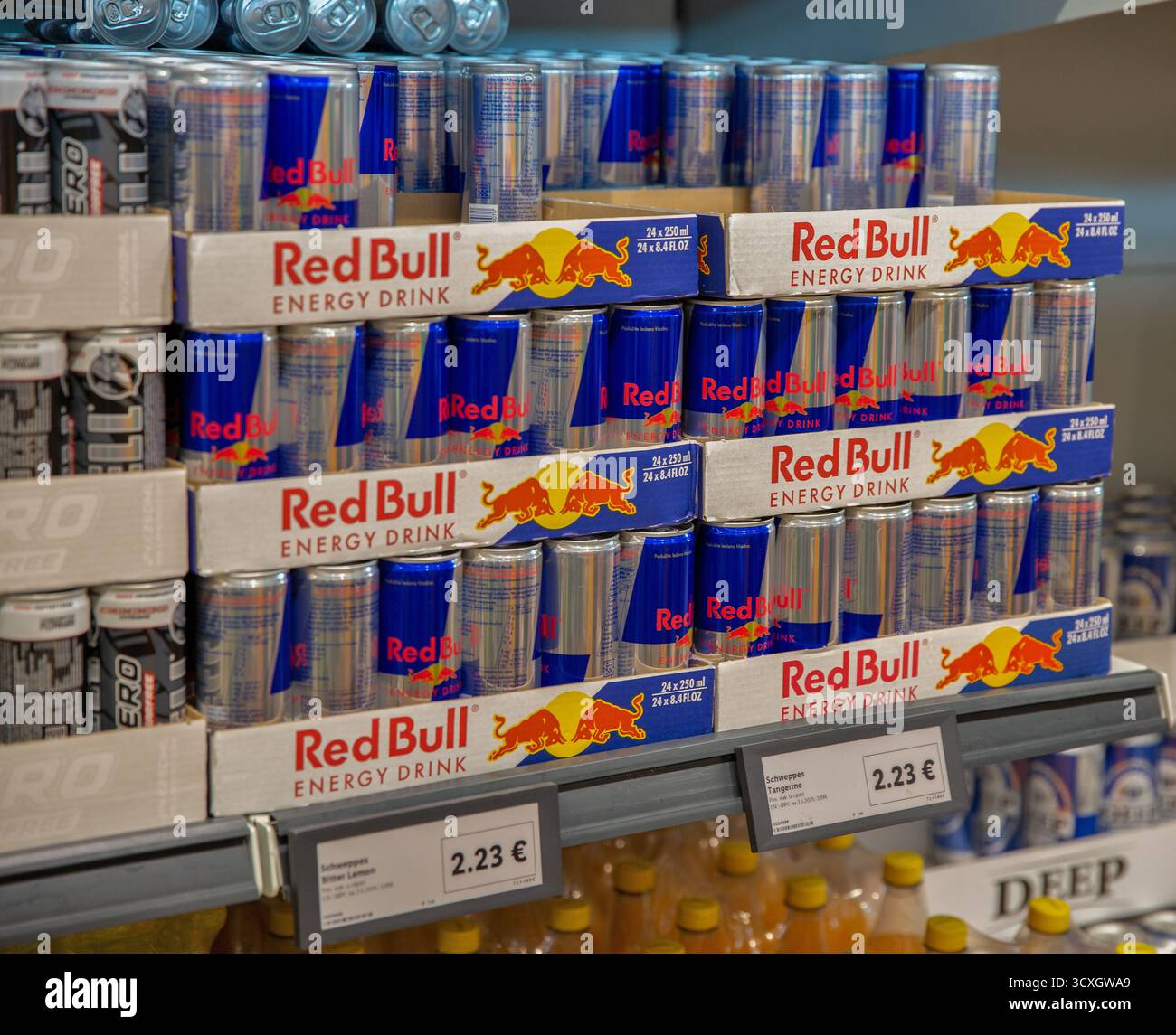 Porec, Croatie - 31 mai 2025 : boîtes de boissons énergisantes et multipacks Red Bull empilées sur les étagères des magasins de détail avec des étiquettes de prix. Boisson caféinée populaire Banque D'Images