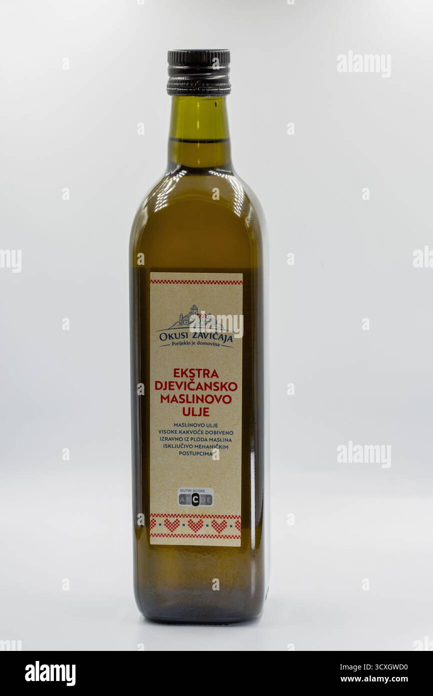 Porec, Croatie - 4 juin 2025 : bouteille en verre d'huile d'olive extra vierge croate avec étiquette en papier kraft avec texte rouge et motif folklorique traditionnel Banque D'Images