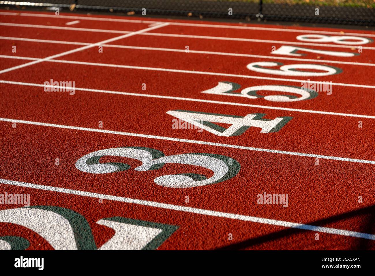 Gros plan photo de voies de piste de course en plein air avec des chiffres blancs trois, quatre cinq, six, sept, huit, 3, 4, 5, 6, 7, 8, avec une ombre verte sur un nouveau rouge Banque D'Images