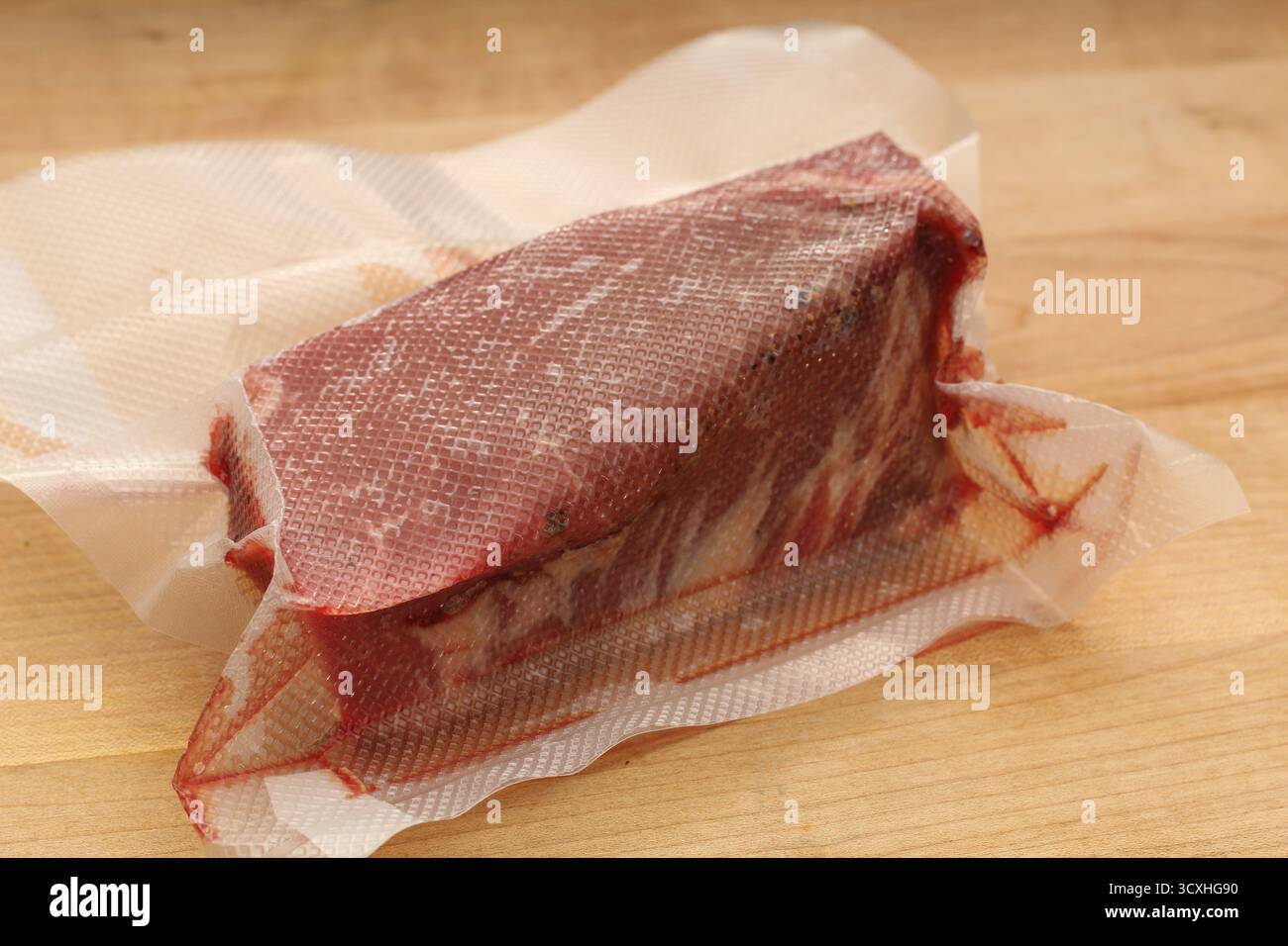 Gros plan du filet de bœuf cru scellé sous vide sur le comptoir de cuisine Banque D'Images