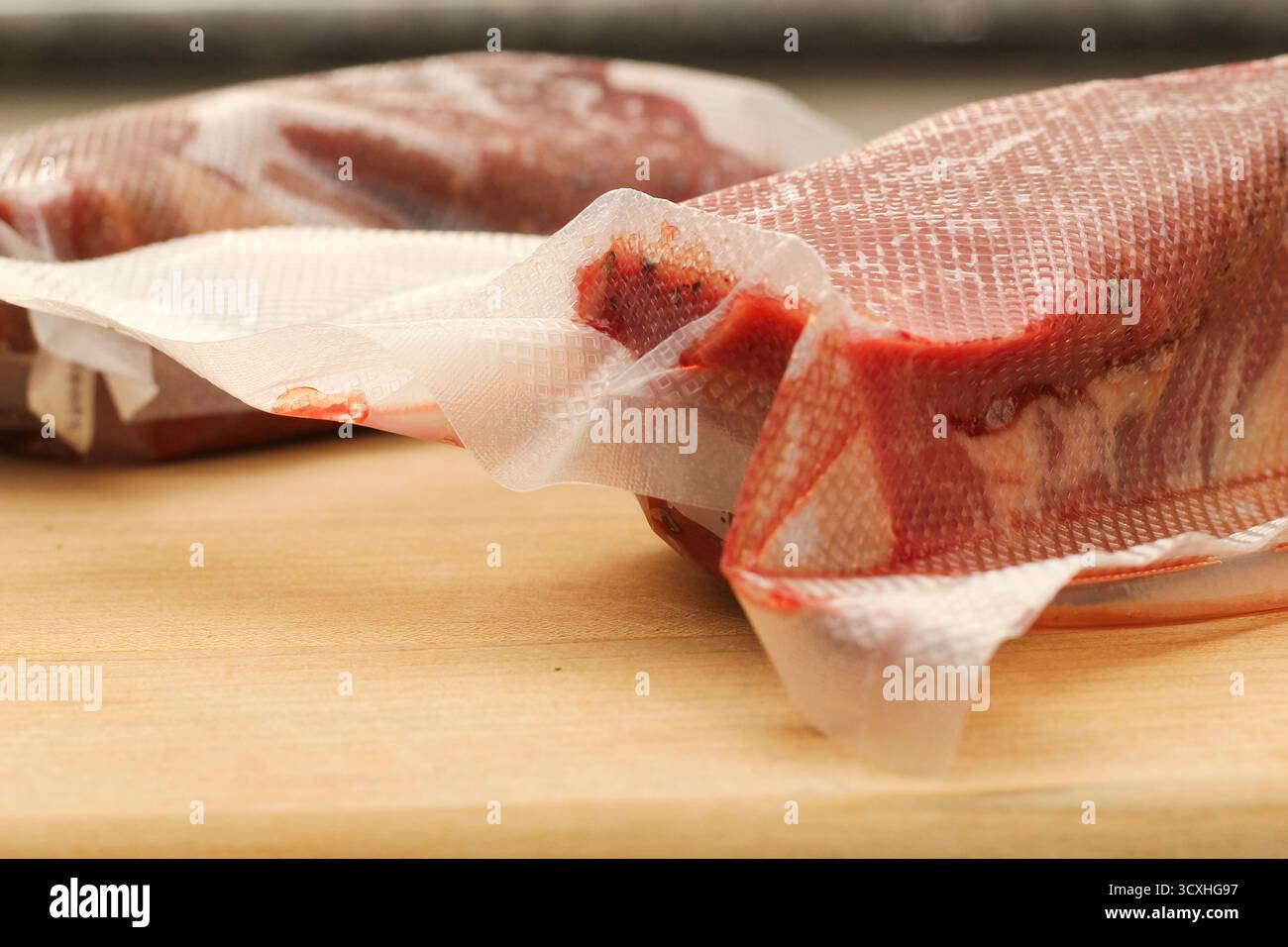 Gros plan du filet de bœuf cru scellé sous vide sur le comptoir de cuisine Banque D'Images