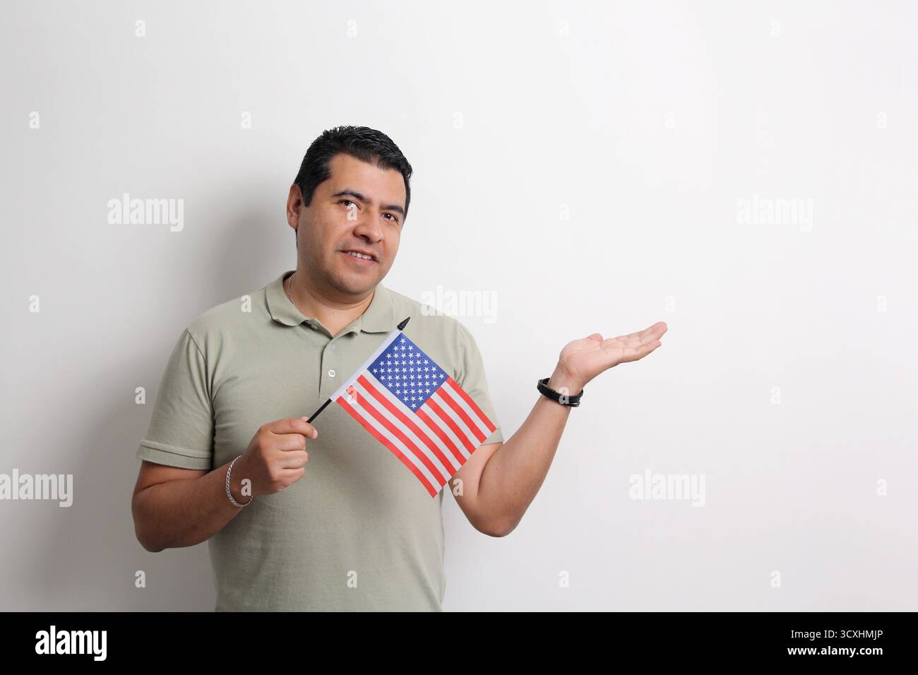 Un homme adulte latino à la peau foncée arbore le drapeau américain, sa nouvelle nationalité en tant que migrant Banque D'Images Un homme adulte latino à la peau foncée arbore le drapeau américain, sa nouvelle nationalité en tant que migrant Banque D'Images