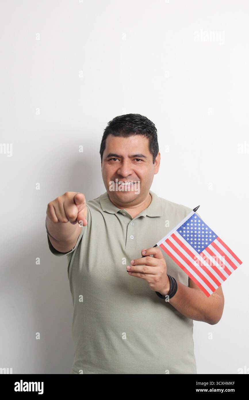 Un homme adulte latino à la peau foncée arbore le drapeau américain, sa nouvelle nationalité en tant que migrant Banque D'Images Un homme adulte latino à la peau foncée arbore le drapeau américain, sa nouvelle nationalité en tant que migrant Banque D'Images